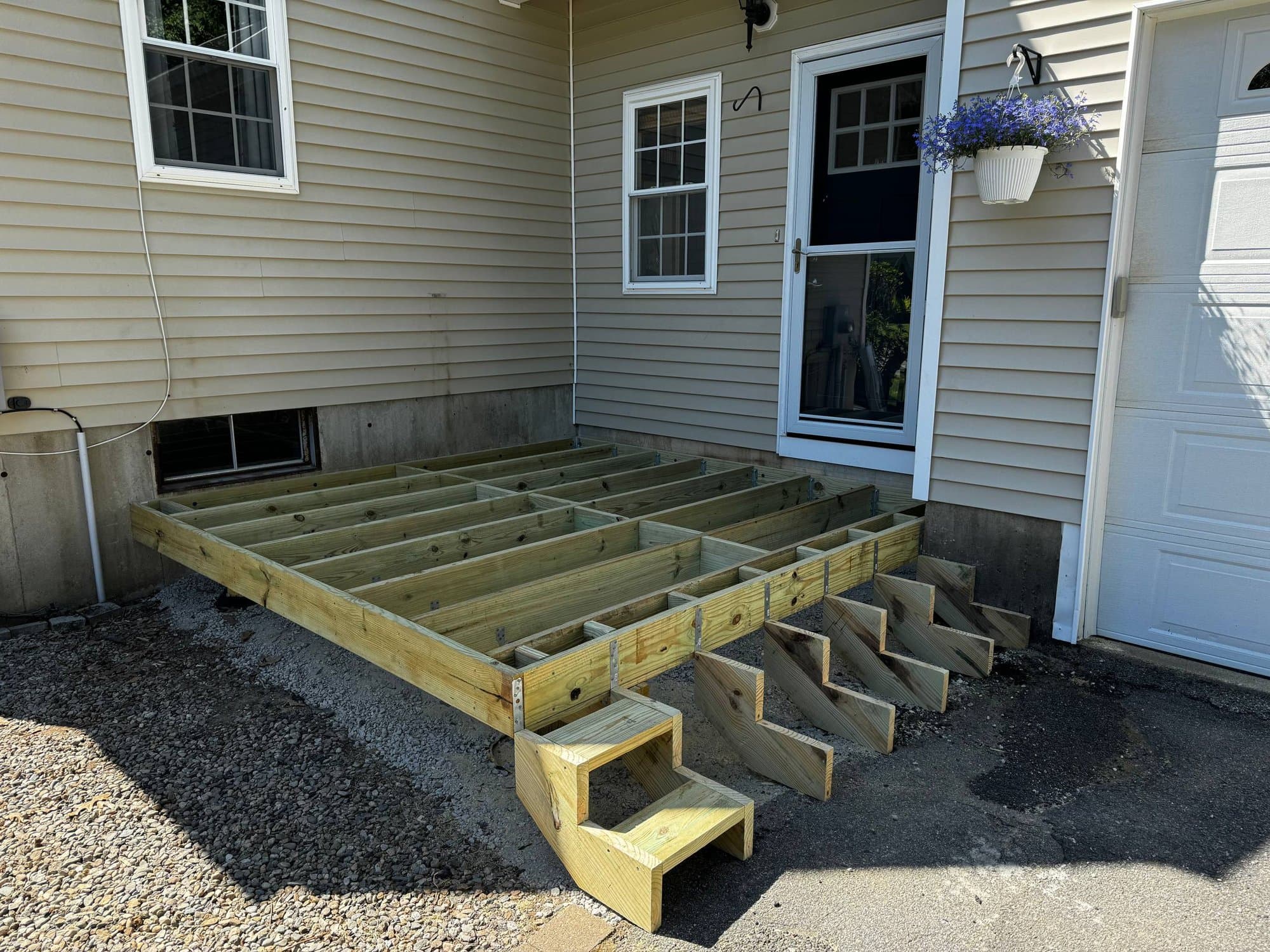 Pressure-treated deck framing with stair stringers installed, ready for decking boards