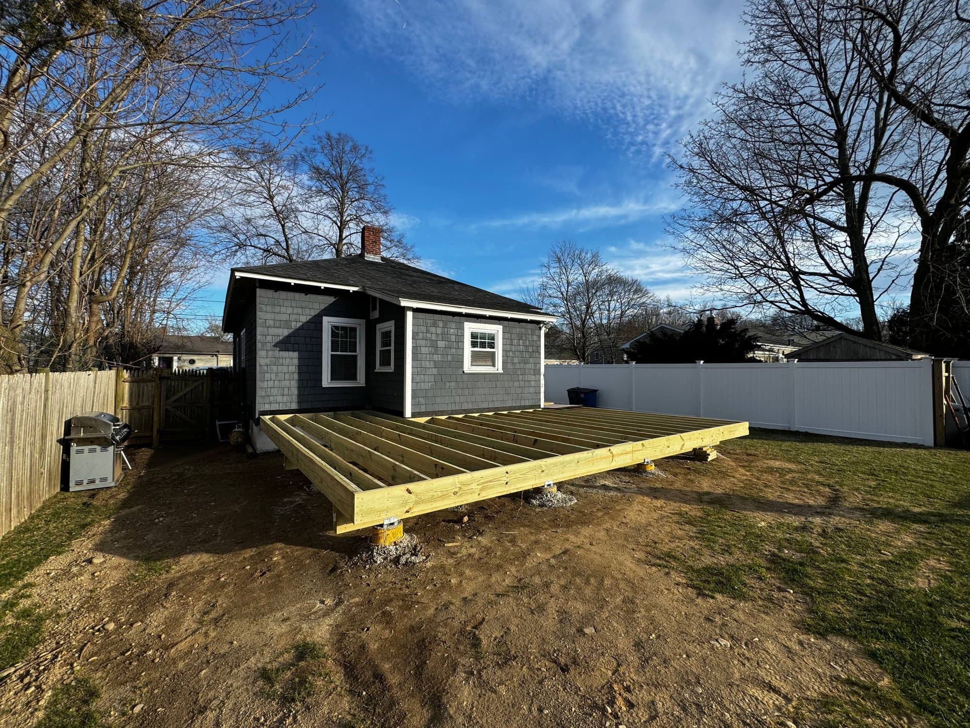 Pressure-treated deck framing installed off the back of the cottage, ready for decking boards