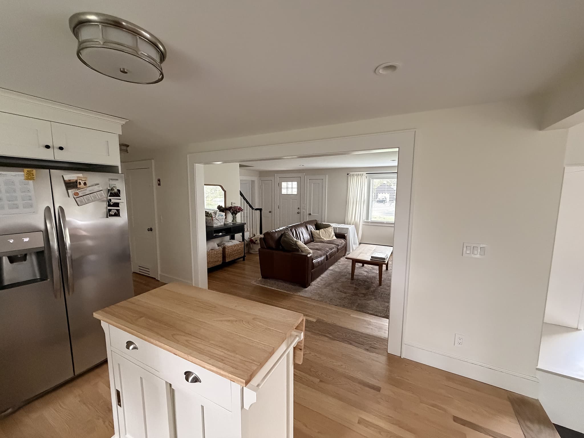 View from the kitchen through the widened opening into the open-concept living room beyond