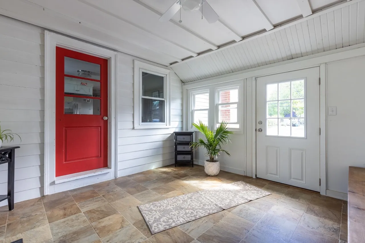Original three-season room from the opposite angle, showing the red exterior door into the old kitchen wall