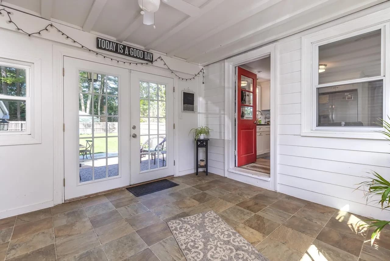 Original three-season room with vaulted painted-wood ceiling, slate tile floor, and exterior French doors to the back yard