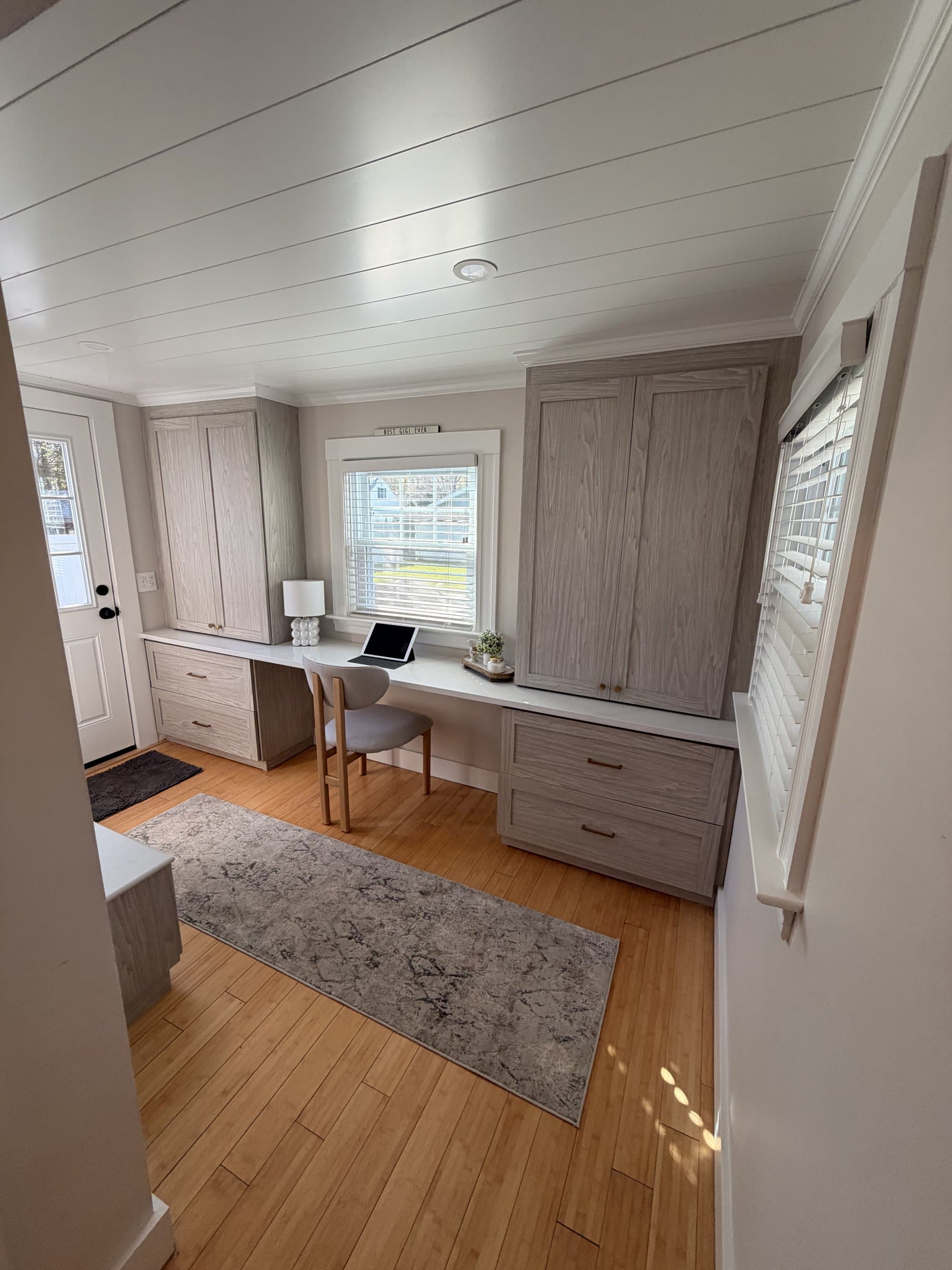 Built-in desk with quartz countertop flanked by floor-to-ceiling cabinetry and brass hardware
