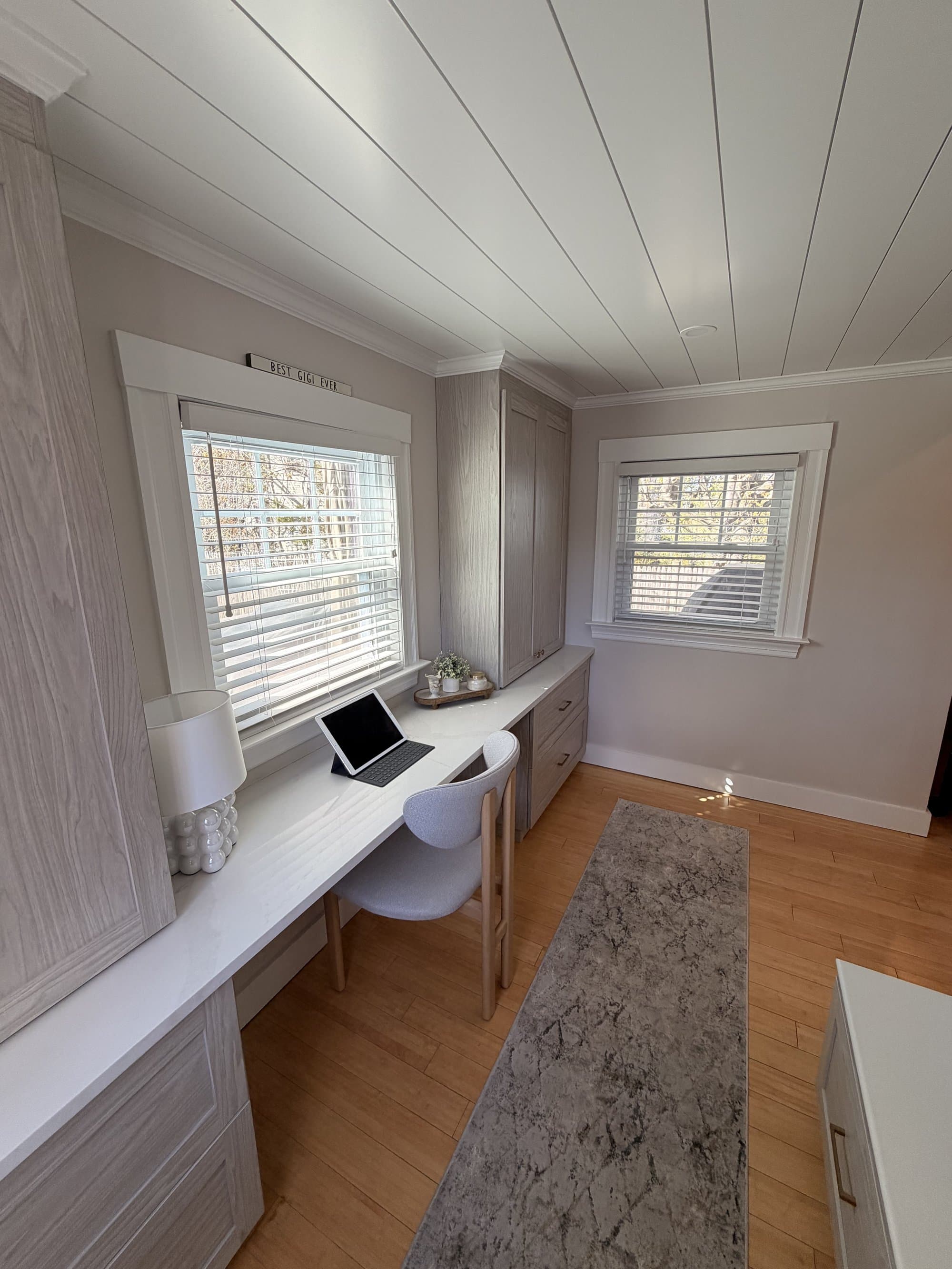 Desk wall with two windows, full quartz counter run, and refinished shiplap ceiling