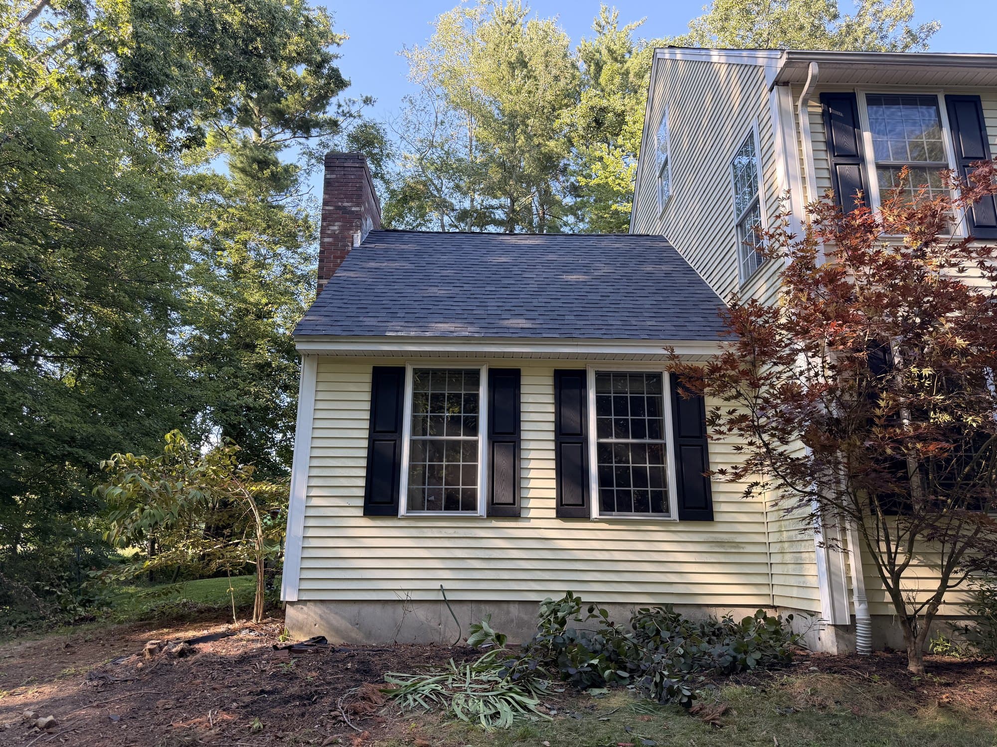 New asphalt shingle roof on the front wing gable, with white drip edge running along the eave
