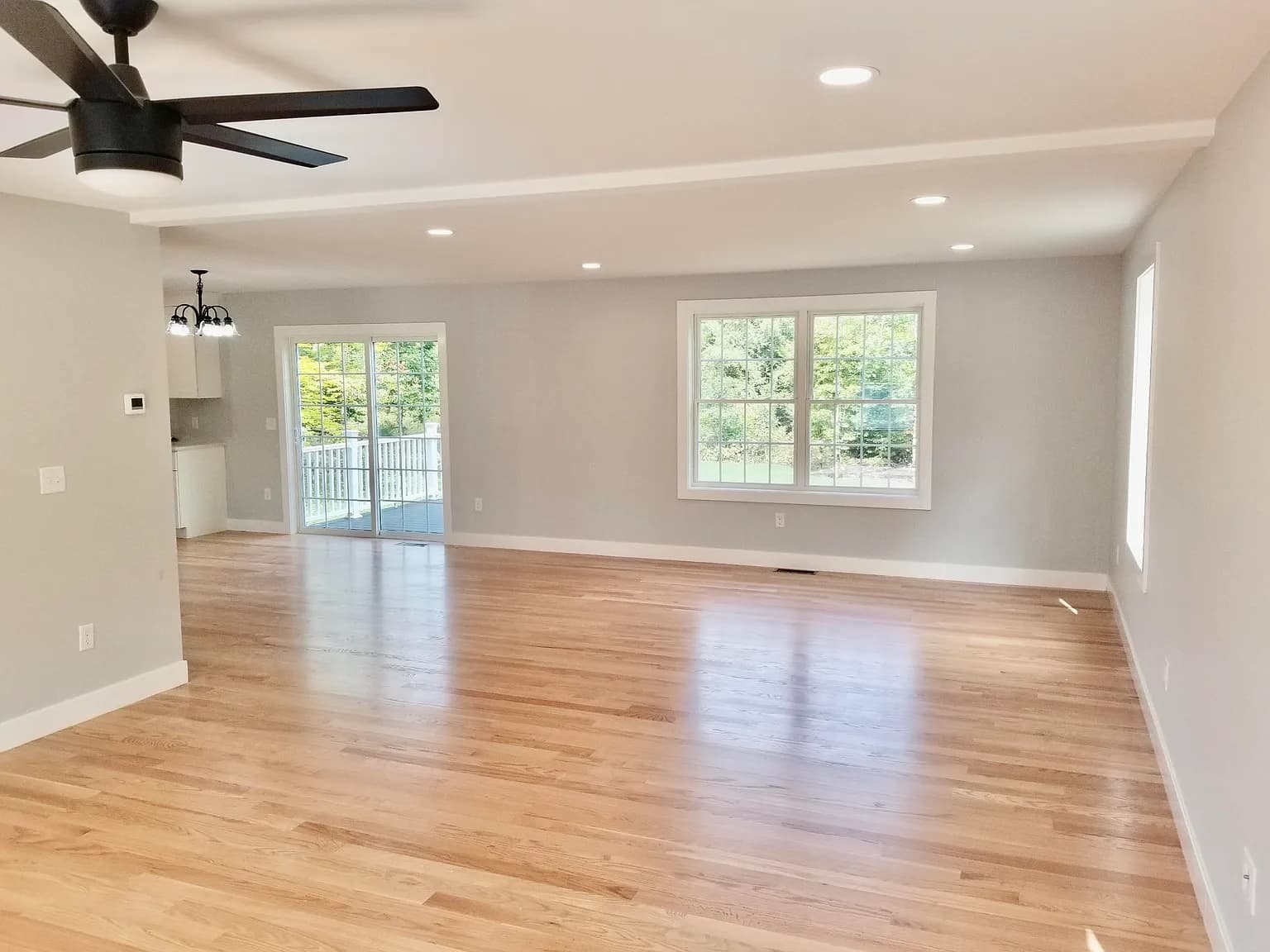 Front-to-back family room with hardwood floors and ceiling fan