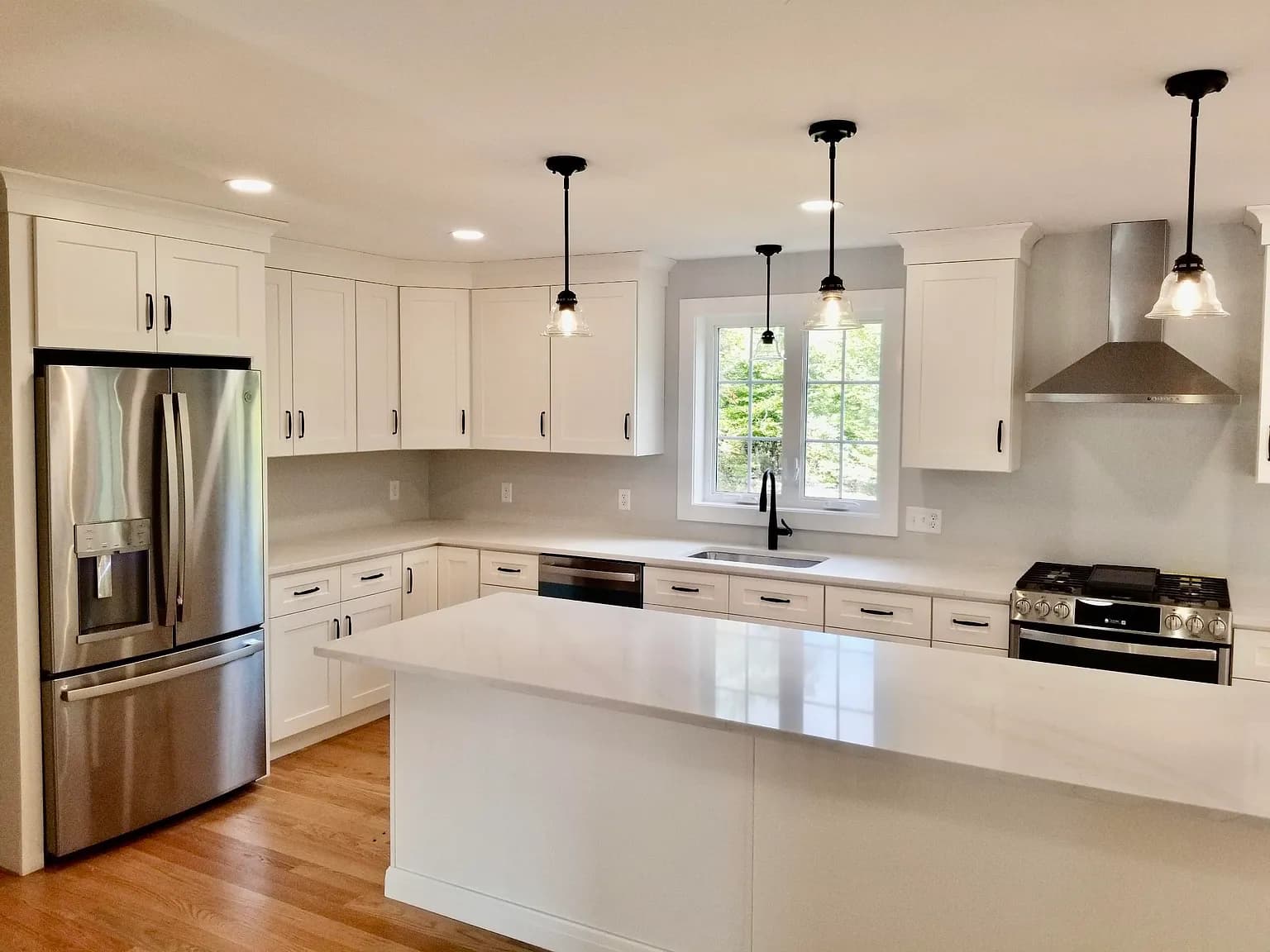Kitchen with stainless appliances, gas range, and vent hood