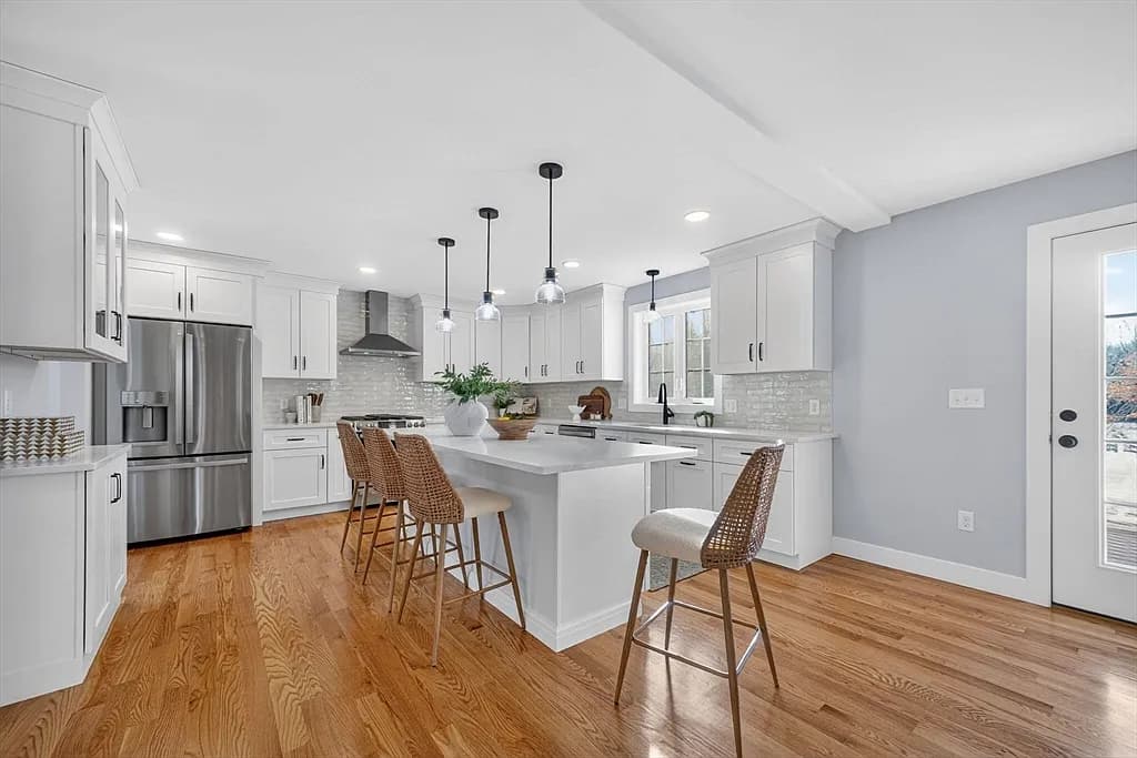 Kitchen island with counter stools and stainless refrigerator