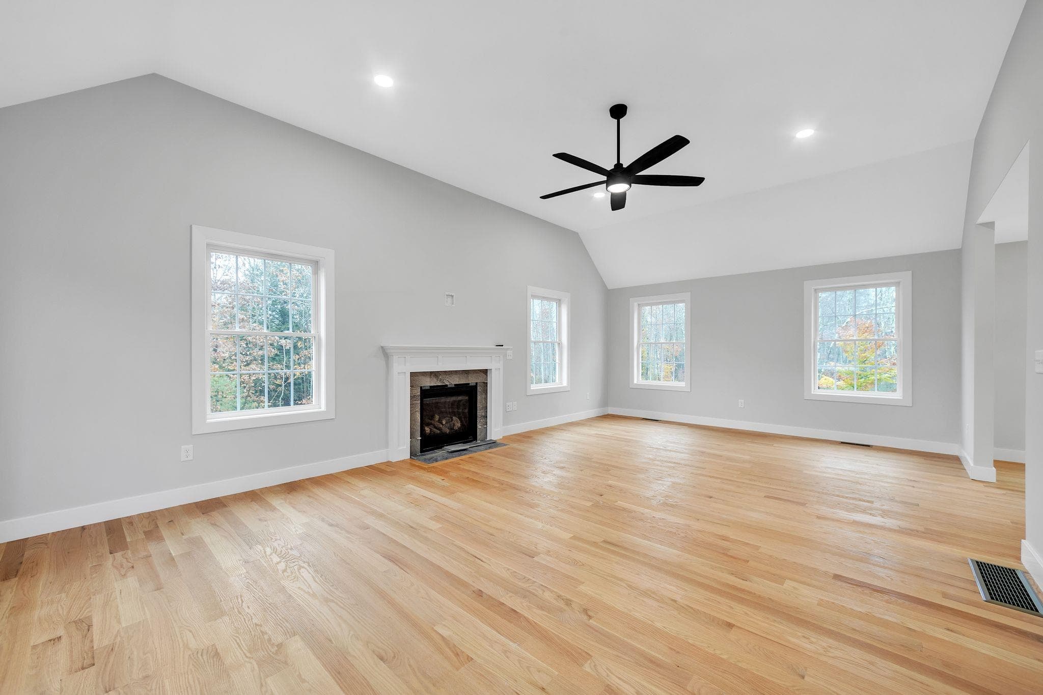 Vaulted family room with ceiling fan and hardwood floors