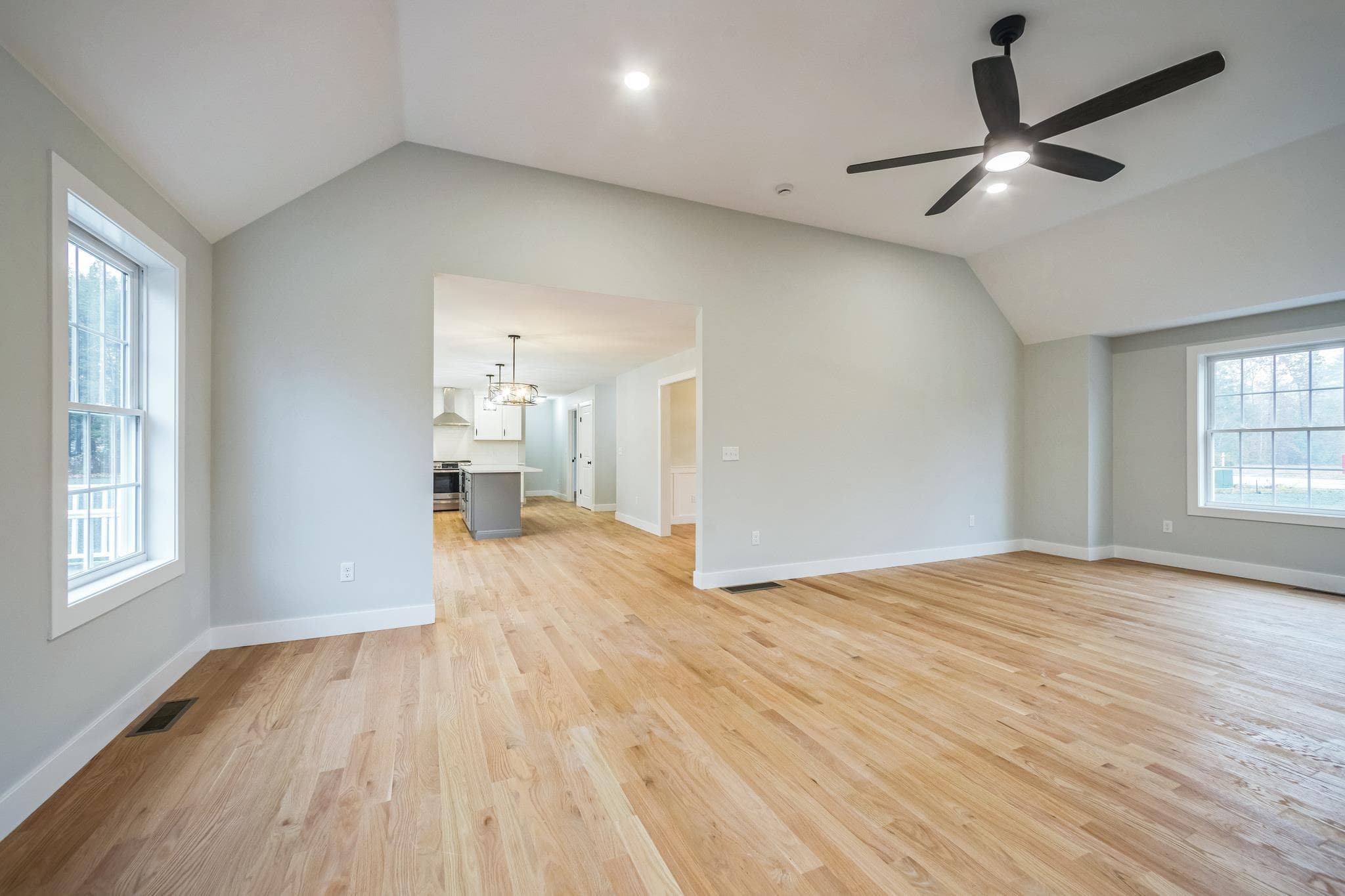 Open-concept kitchen flowing into dining area with chandelier